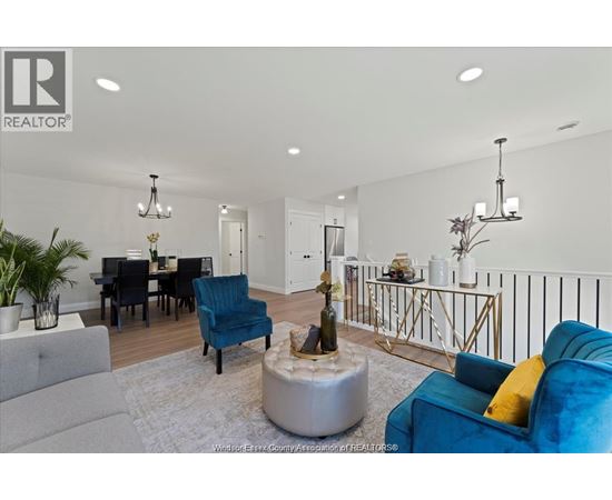 A living room with a grey sofa, a blue armchair, a coffee table, and a dining table with chairs.
