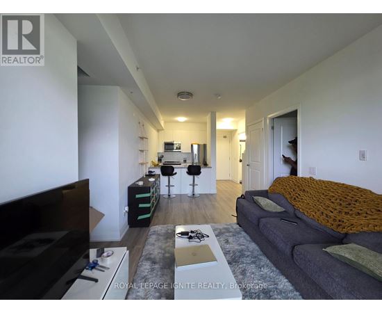 A living room with a grey couch and a black television.