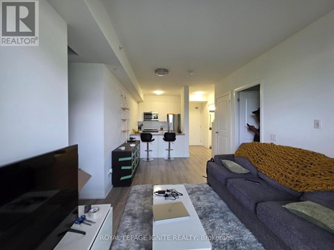 A living room with a grey couch and a black television.