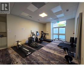A gym room with a treadmill, elliptical trainer, and weights.