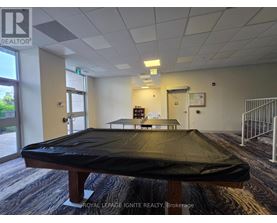 A room with a pool table and a sign that says "Royal LePage Ignite Realty Brokerage".