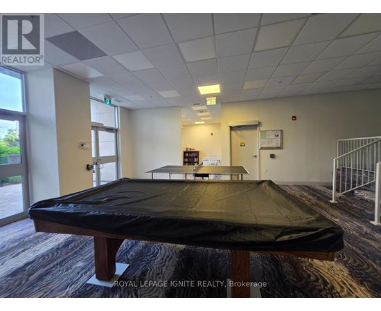 A room with a pool table and a sign that says "Royal LePage Ignite Realty Brokerage".