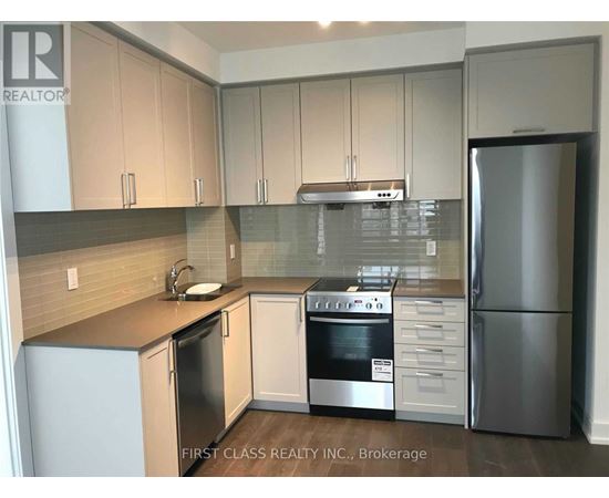 A kitchen with a refrigerator, oven, and sink.