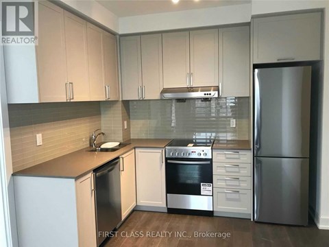 A kitchen with a refrigerator, oven, and sink.