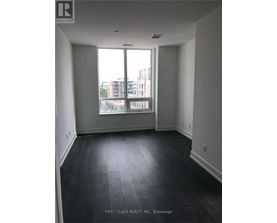 A room with a large window and dark flooring.