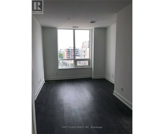 A room with a large window and dark flooring.