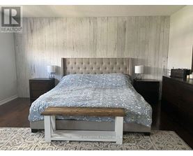 A bedroom with a bed, nightstands, and a bench.