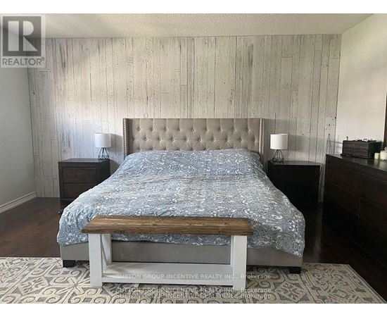 A bedroom with a bed, nightstands, and a bench.