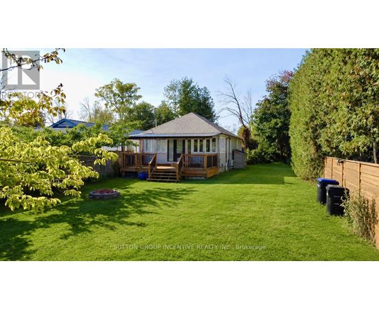 A house with a deck and a gazebo in a yard.