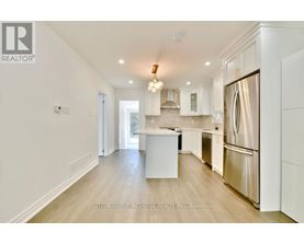 A modern kitchen with white cabinets and a stainless steel refrigerator.