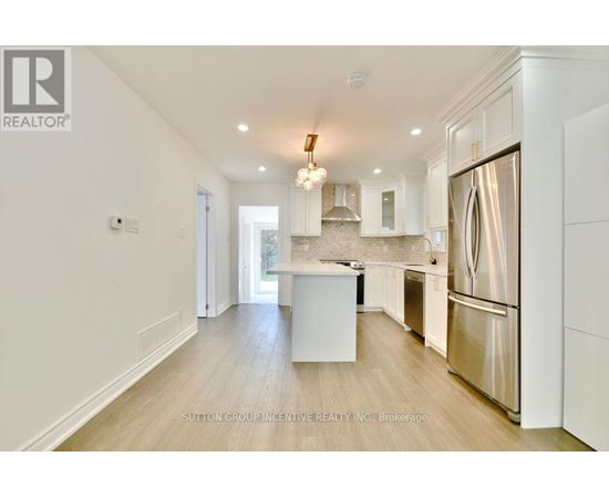 A modern kitchen with white cabinets and a stainless steel refrigerator.