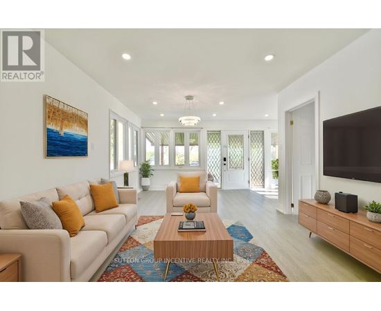 A living room with a white couch, a coffee table, and a painting on the wall.