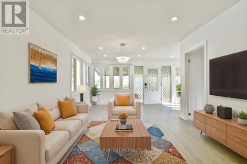 A living room with a white couch, a coffee table, and a painting on the wall.