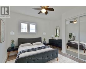 A bedroom with a large bed and a ceiling fan.