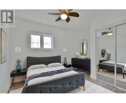 A bedroom with a large bed and a ceiling fan.