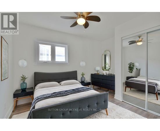 A bedroom with a large bed and a ceiling fan.
