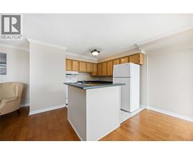 A kitchen with white cabinets and a wooden backsplash.
