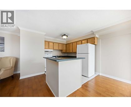 A kitchen with white cabinets and a wooden backsplash.