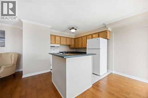 A kitchen with white cabinets and a wooden backsplash.