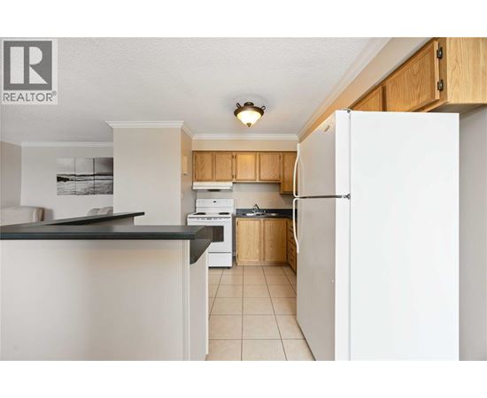 A kitchen with white appliances and wooden cabinets.