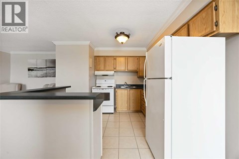 A kitchen with white appliances and wooden cabinets.