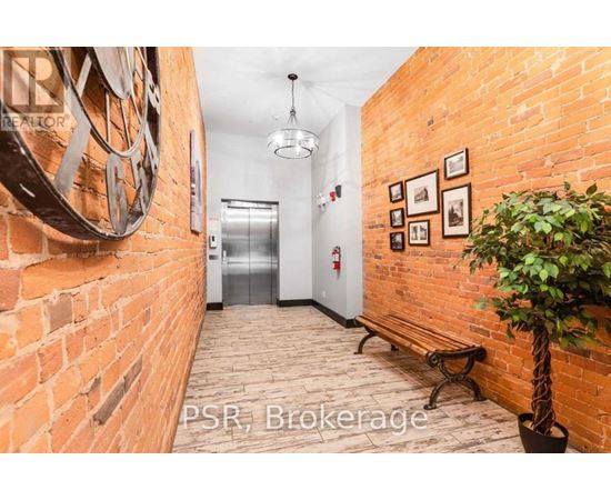 A hallway with a brick wall and a tree in a pot.
