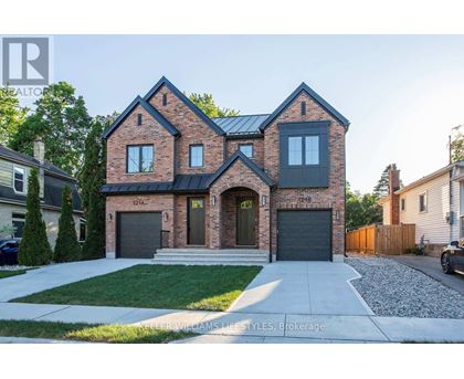 A modern brick house with a black roof and a garage door.