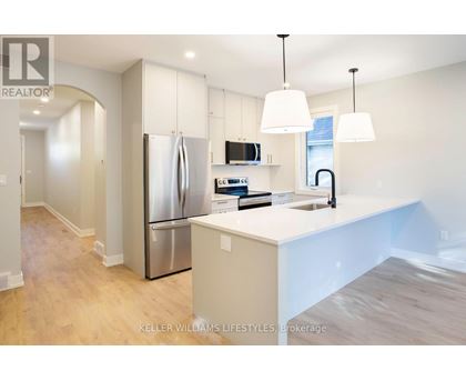 A modern kitchen with a stainless steel refrigerator and white countertops.