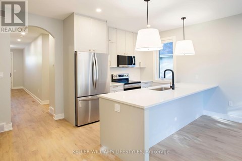 A modern kitchen with a stainless steel refrigerator and white countertops.