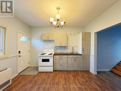 A kitchen with a white stove top oven and wooden cabinets.
