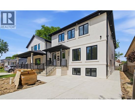 A modern house with a large front yard is for sale.