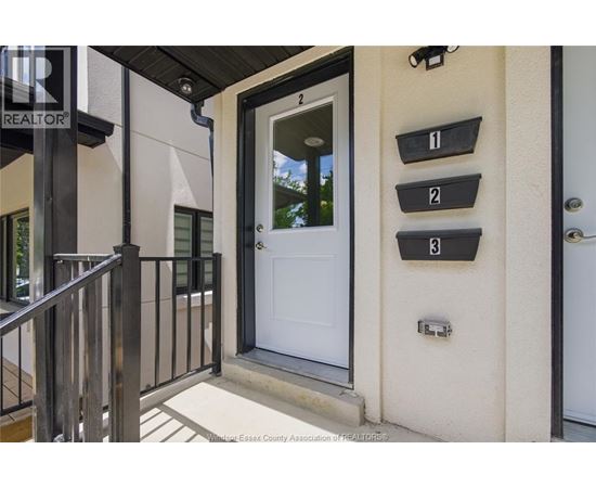 A white door is on the right side of a black railing.