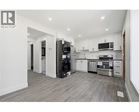A modern kitchen with white cabinets and stainless steel appliances.