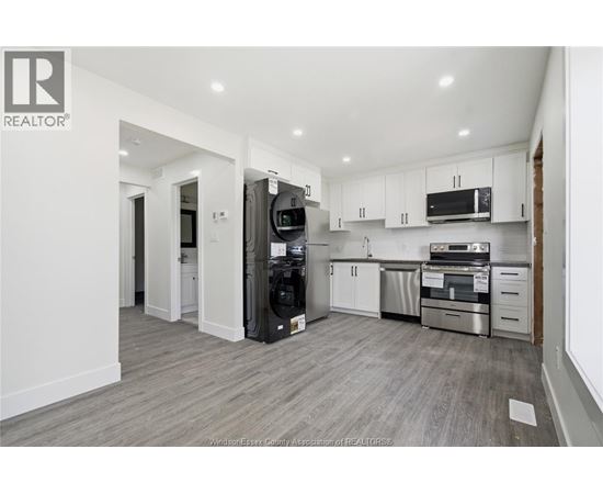 A modern kitchen with white cabinets and stainless steel appliances.