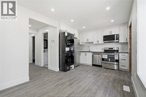 A modern kitchen with white cabinets and stainless steel appliances.