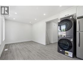A modern kitchen with a washing machine in the middle of the room.