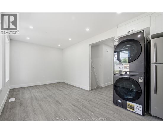 A modern kitchen with a washing machine in the middle of the room.