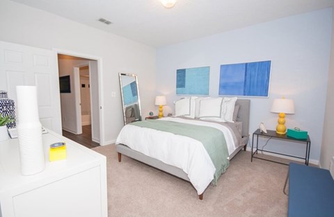 A bedroom with a bed, nightstand, and lamp.