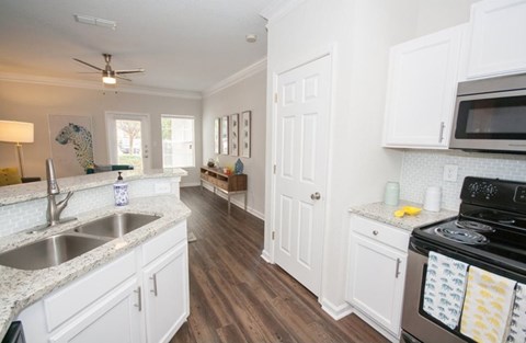 A kitchen with white cabinets and a black stove top.