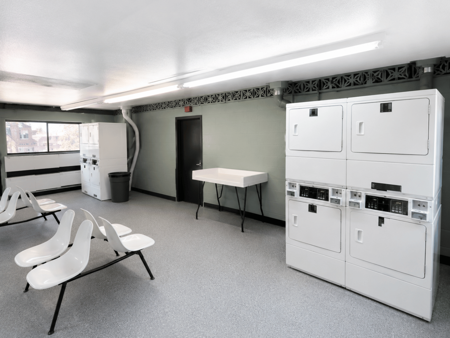 A room with white chairs and cabinets.