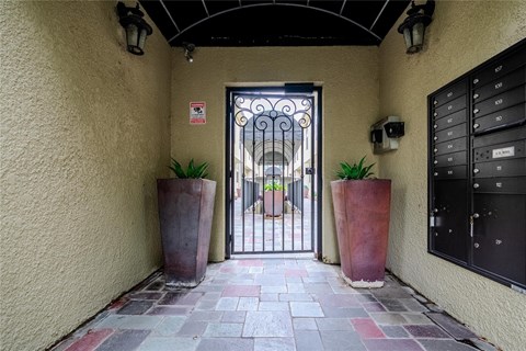 A black gate with a decorative design is the entrance to a building.