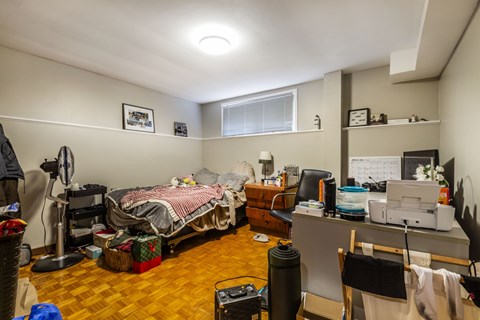 A room with a bed, desk, and chair.