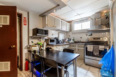 A kitchen with a table and chairs.