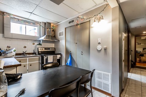 A kitchen with a table and chairs.