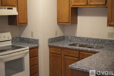 A kitchen with granite countertops and wooden cabinets.