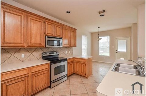 A kitchen with wooden cabinets and a stove top oven.