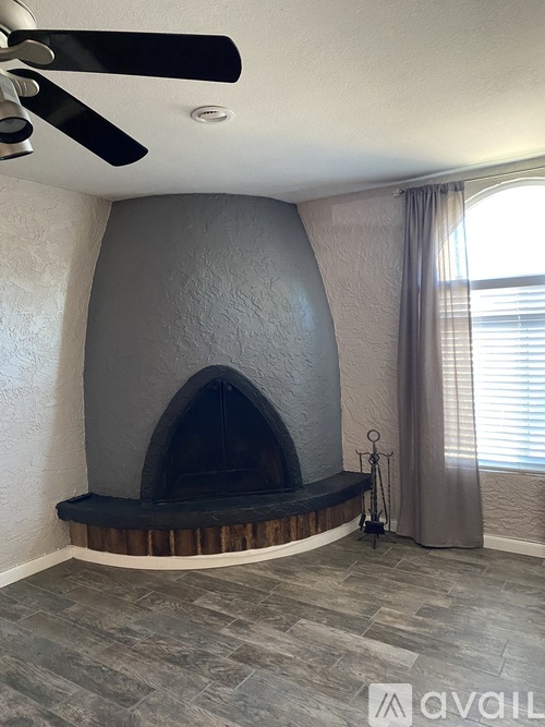A modern living room with a fireplace and a ceiling fan.