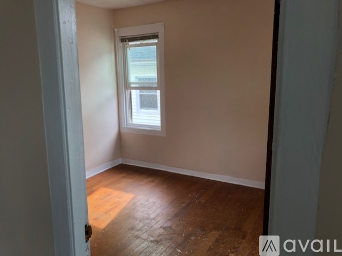 A room with wooden flooring and a window.
