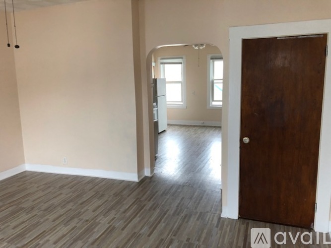 A room with a wooden floor and a brown door.