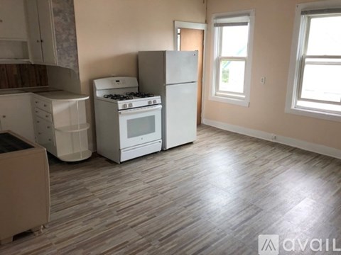 A kitchen with a white stove, oven, and refrigerator.